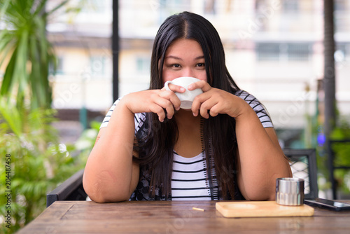 Photography Beautiful overweight Asian woman relaxing at the coffee shop