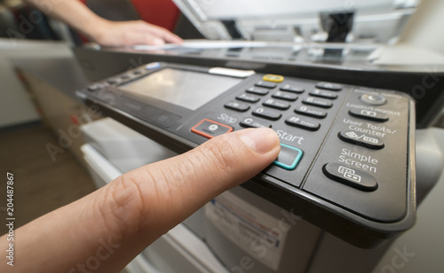 Man pushing copy button to copying paper from Photocopier