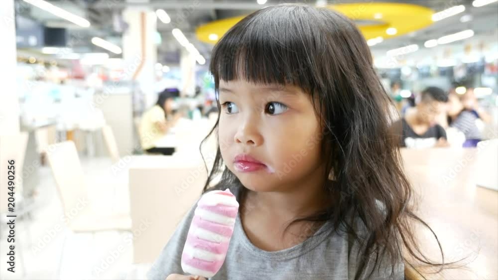 A sweety girl look like enjoy the taste of ice cream tube. A sweety girl look like enjoy the taste of ice cream tube.