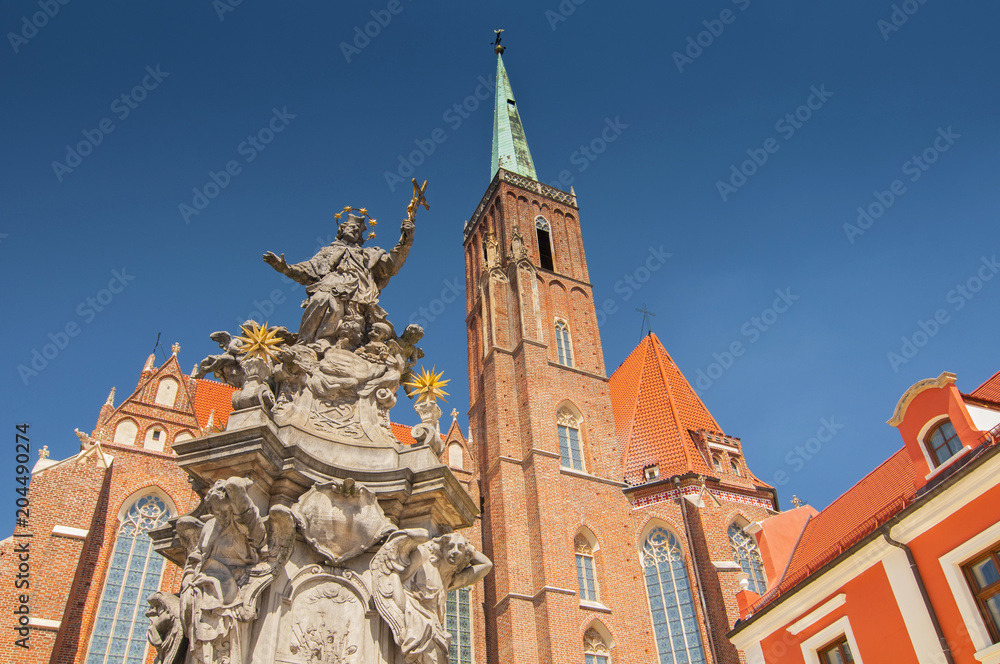 Church of the Holy Cross and St Bartholomew and  statue of John of Nepomuk in Wroclaw, Poland.