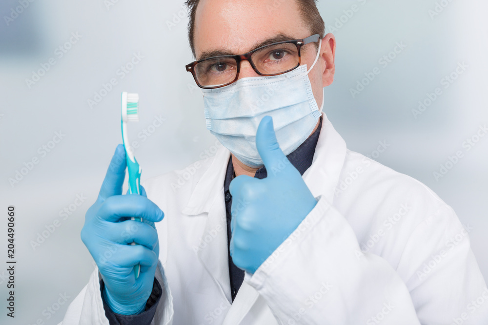 Zahnarzt mit Mundschutz und Zahnbürste zeigt Daumen hoch Stock-Foto | Adobe  Stock