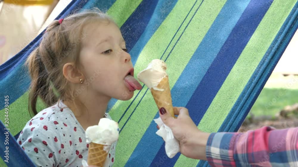 Child girl enjoy eating sweets licking ice cream cone while ...
