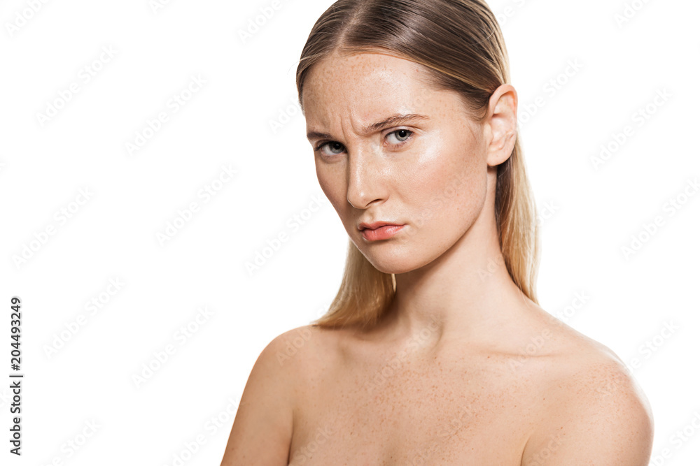 Waist up portrait of concentrate pretty girl. Charming nude female knitting brows and looking at camera with gravely and warily. Isolated on white background Waist up portrait of concentrate pretty girl. Charming nude female knitting brows and looking at camera with gravely and warily. Isolated on white background
