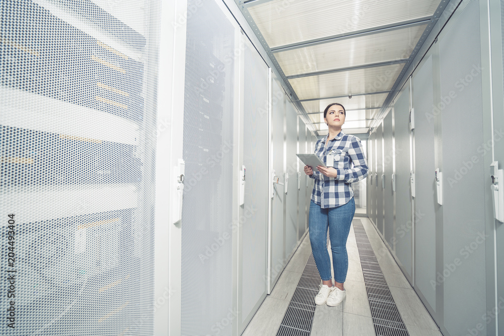 Woman technician working on and inspecting servers in server room Woman technician working on and inspecting servers in server room