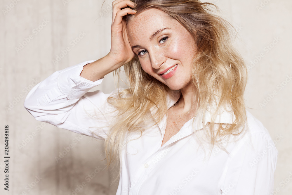 Waist up portrait of pretty young woman in white shirt. Alluring girl with amazing hair and natural make-up standing and looking at camera with happiness and tenderness Waist up portrait of pretty young woman in white shirt. Alluring girl with amazing hair and natural make-up standing and looking at camera with happiness and tenderness