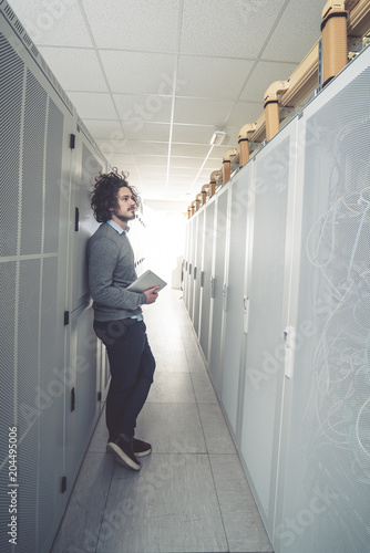 male technician inspecting and working on servers in server room © fotoinfot