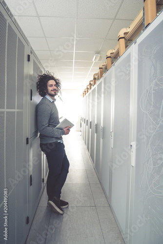 male technician inspecting and working on servers in server room © fotoinfot