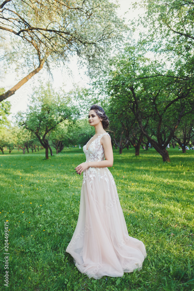 The stunning young bride is incredibly happy. A beautiful bride portrait in the park.