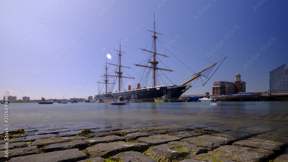 Fototapeta premium HMS Warrior (1862) - the first British ironclad battleship built for the Royal Navy - in spring afternoon light with slow shutter speed, Portsmouth, Hampshire, UK