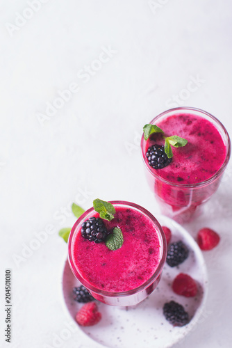 Blackberry and raspberry smoothies in glass with mint leaf and raw beeries photo