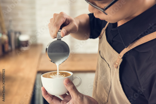 Barista making Rosetta shape latte art coffee