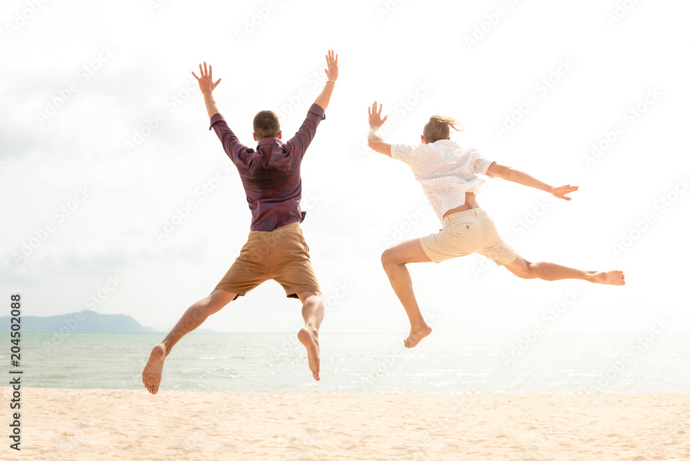 Young energetic happy tourist men jumping at the beach Young energetic happy tourist men jumping at the beach