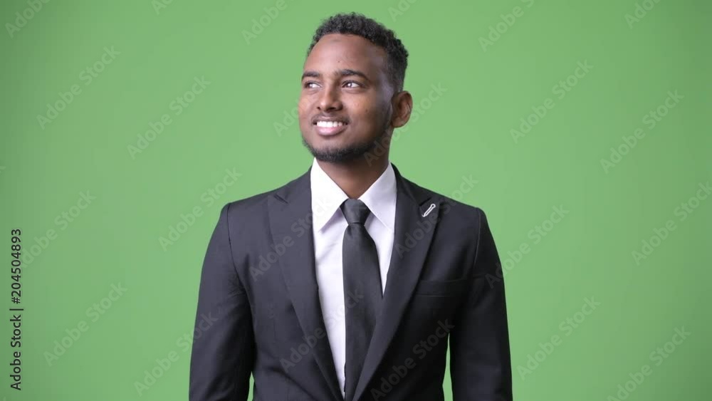 Young handsome African businessman against green background Young handsome African businessman against green background