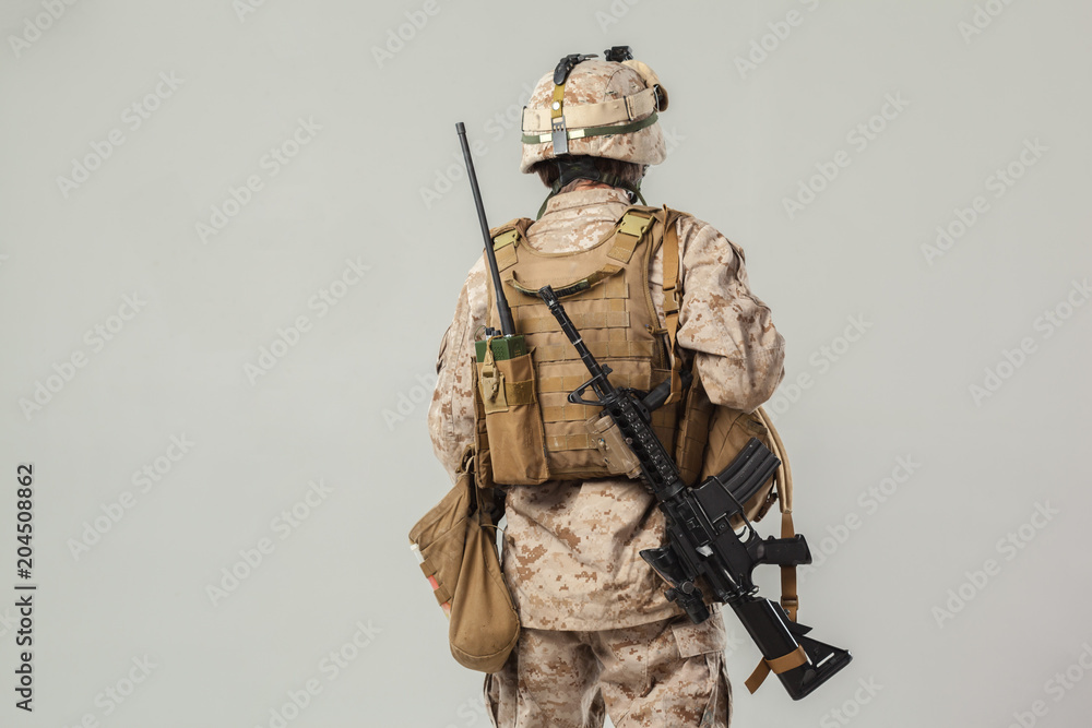 Fototapeta premium Soldier in camouflage holding rifle