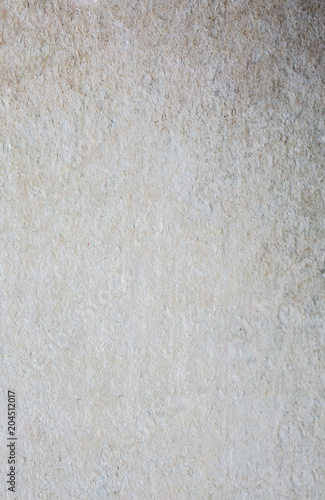 Abstract white beige texture. Ribbed concrete background with small holes and stains. Old vintage wall.