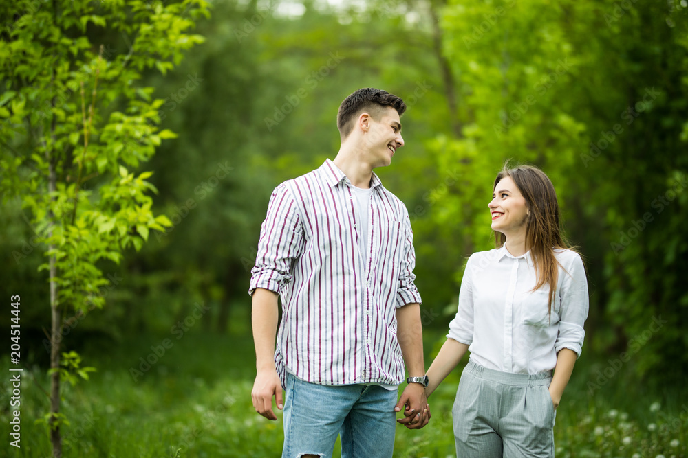 Beautiful young in love couple taking a walk in city park Beautiful young in love couple taking a walk in city park