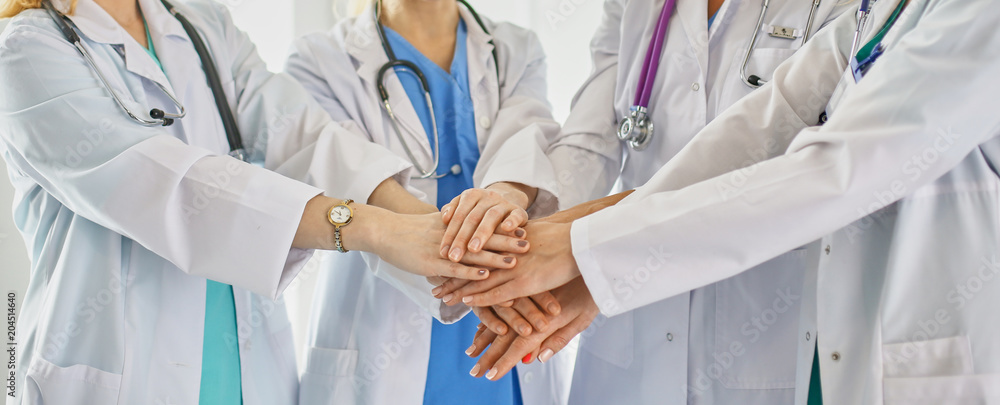 Doctors and nurses in a medical team stacking hands Doctors and nurses in a medical team stacking hands
