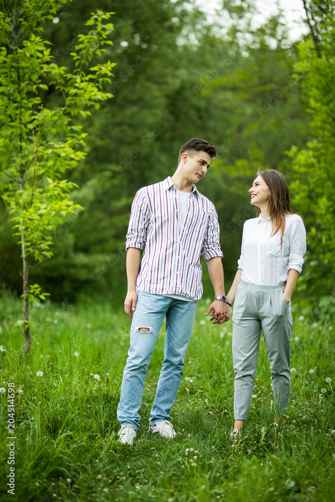 Beautiful young in love couple taking a walk in city park Beautiful young in love couple taking a walk in city park