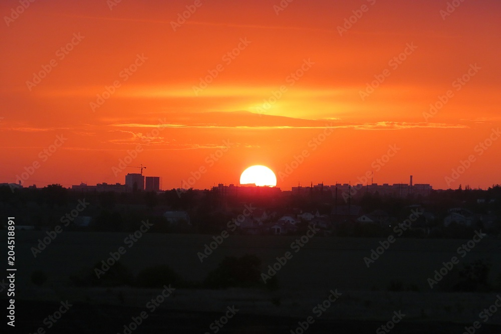 Beautiful fiery orange sunset over the city, the sun sets over the horizon Beautiful fiery orange sunset over the city, the sun sets over the horizon