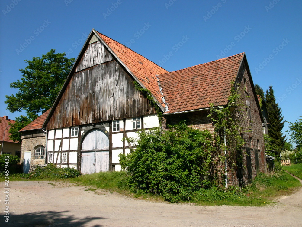 Schöner alter Bauernhof mit Holz und Fachwerk vor blauem Himmel bei