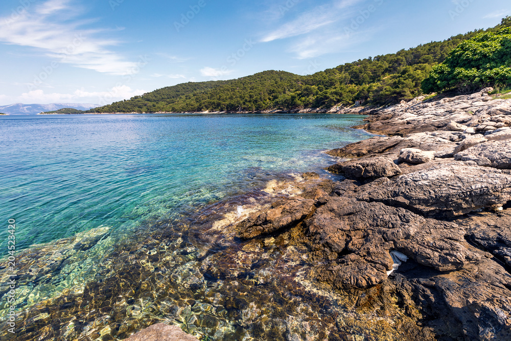 Beautiful view from the rocky coast to the azure sea.Landscape of rocky seashore with clear water of sea