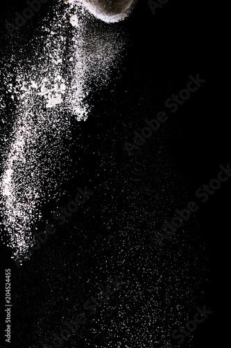 Flour sifting on a black background. White powder sift isolated on black background. Copy space