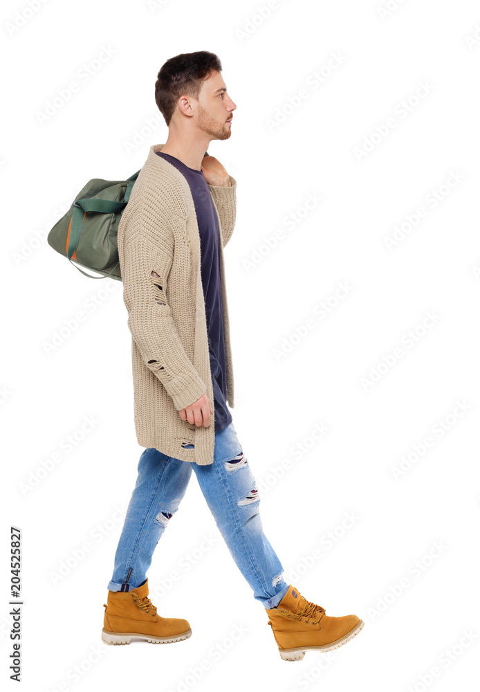 Naklejka premium back view of walking man with green bag.