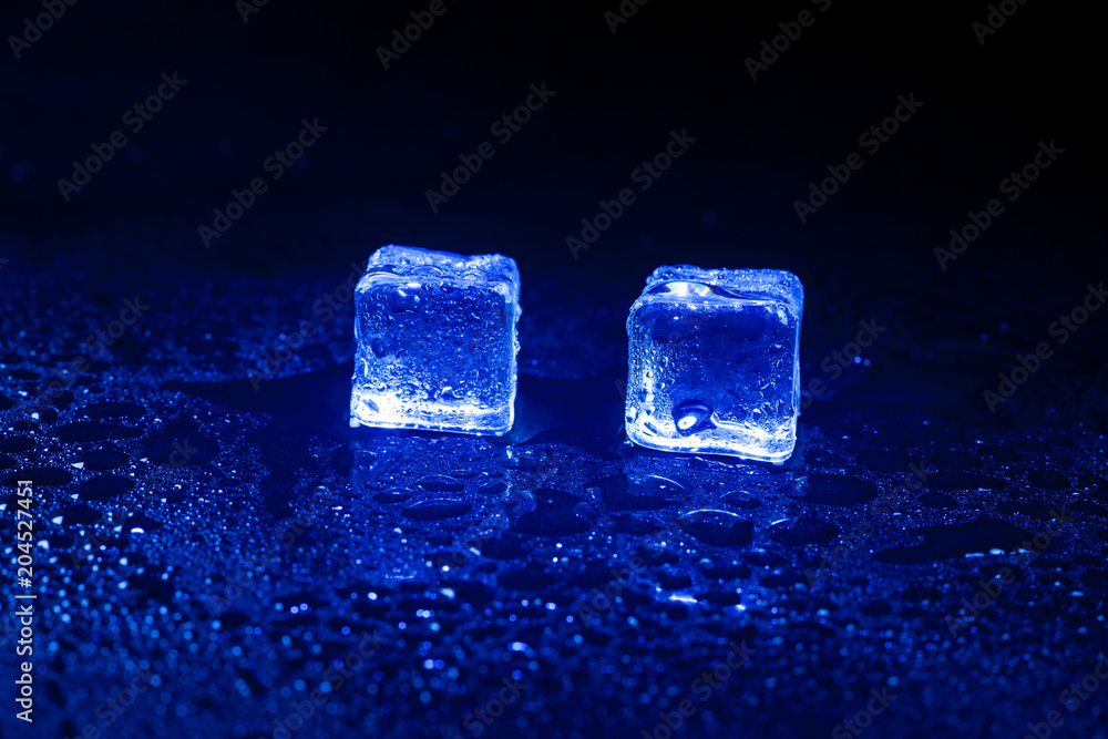 Obraz premium Blue ice cubes on black background.
