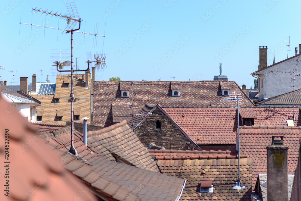 Red tiled rooftops in a town with antennae