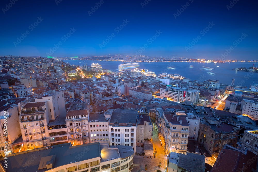 Obraz premium Long exposure cityscape of Istanbul at a night from Galata to the Bosphorus. Wonderful romantic old town at Sea of Marmara. Bright light of street lighting and cruise liners. Istanbul. Turkey.