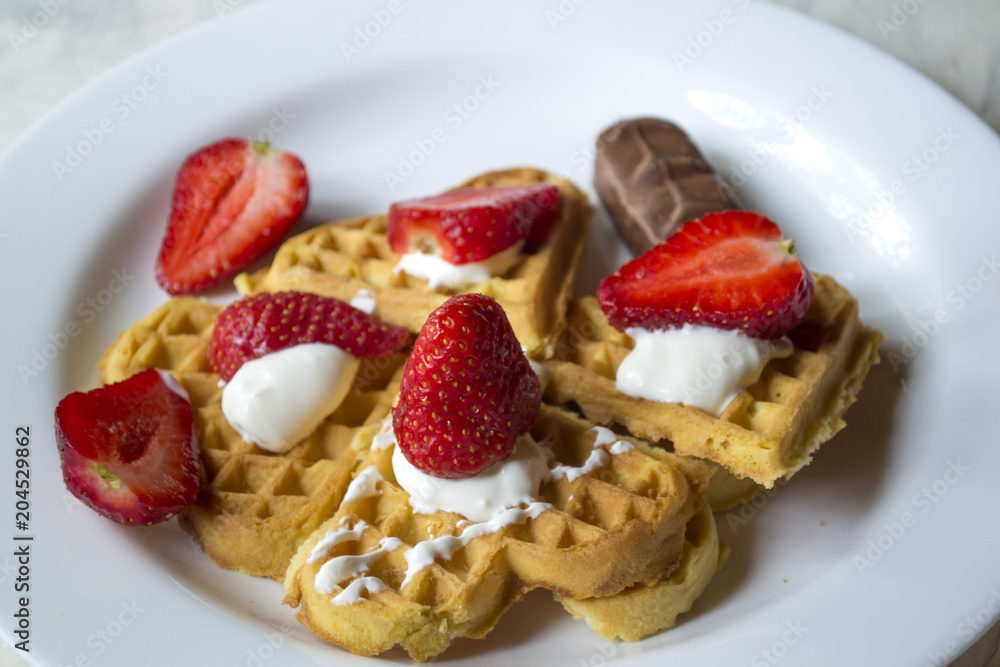 Ripe strawberry on waffles close up. Beautiful and tasty breakfast. Ripe strawberry on waffles close up. Beautiful and tasty breakfast.