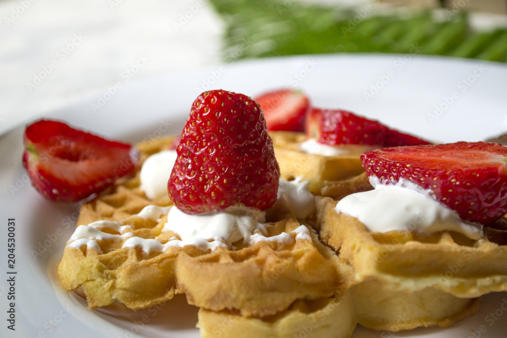 Ripe strawberry on waffles close up. Beautiful and tasty breakfast.