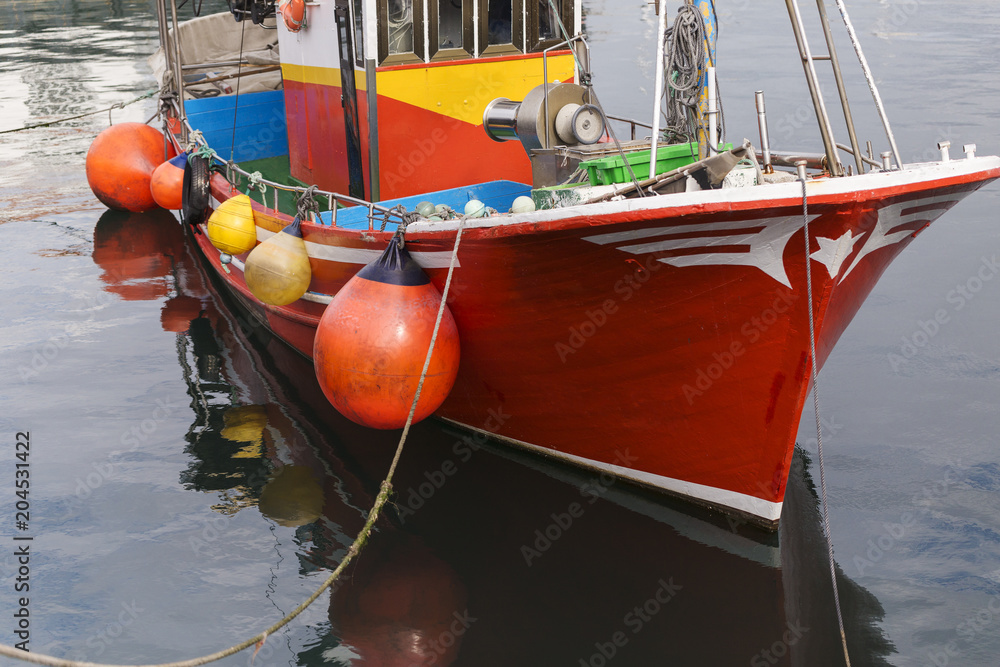 details of a fishing boat moored in a small harbor
