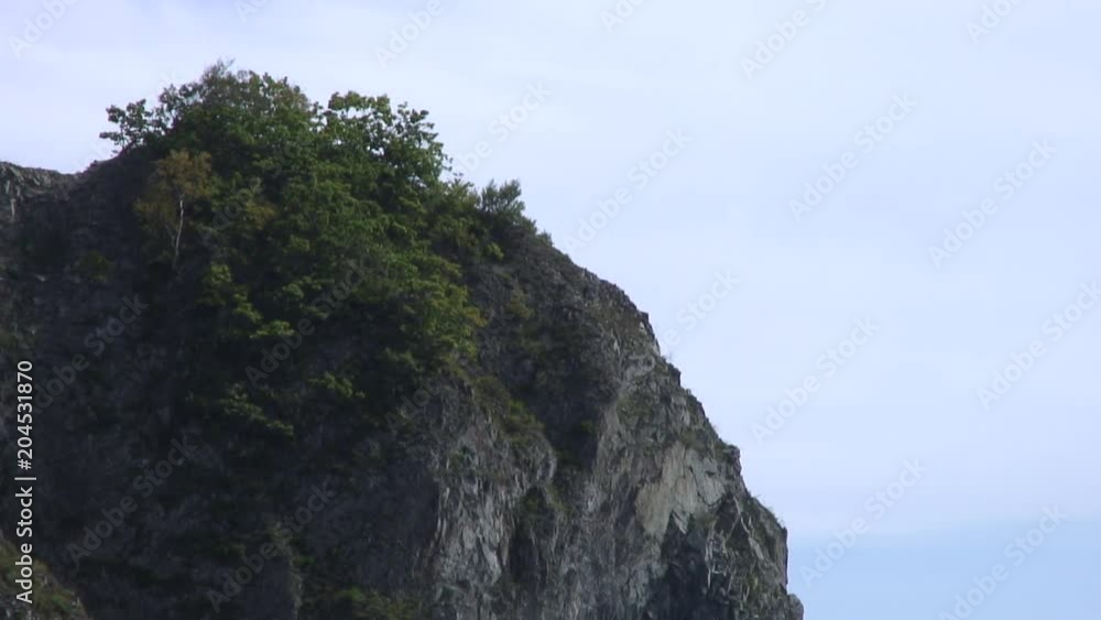 Green stony rocks coastline beach and sea waves water surface in Japan Sea. Calmness and silence. Rest and tourism in beautiful place. Unique landscape and background. Green stony rocks coastline beach and sea waves water surface in Japan Sea. Calmness and silence. Rest and tourism in beautiful place. Unique landscape and background.