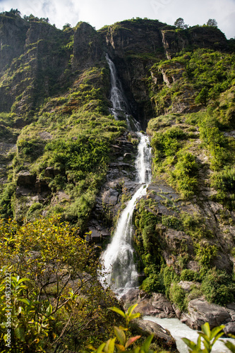 Scenic Himalayan Landscape. View of Waterfall, Mountains and forest. Annapurna Range on Annapurna Circuit Trek. Autumn season in Nepal, Asia.