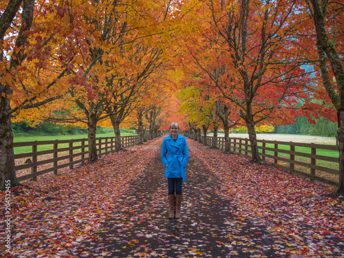 Woman enjoying fall colors in road