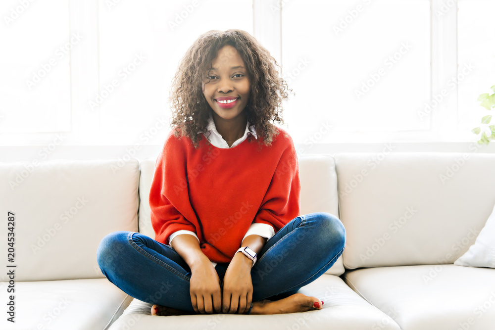 Obraz premium Attractive black young woman relaxing on a sofa at home