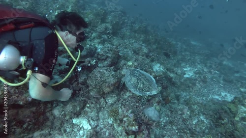 Male scuba diver with sidemount swims with sea turtle over the coral reef - Indian Ocean, Maldives
 photo