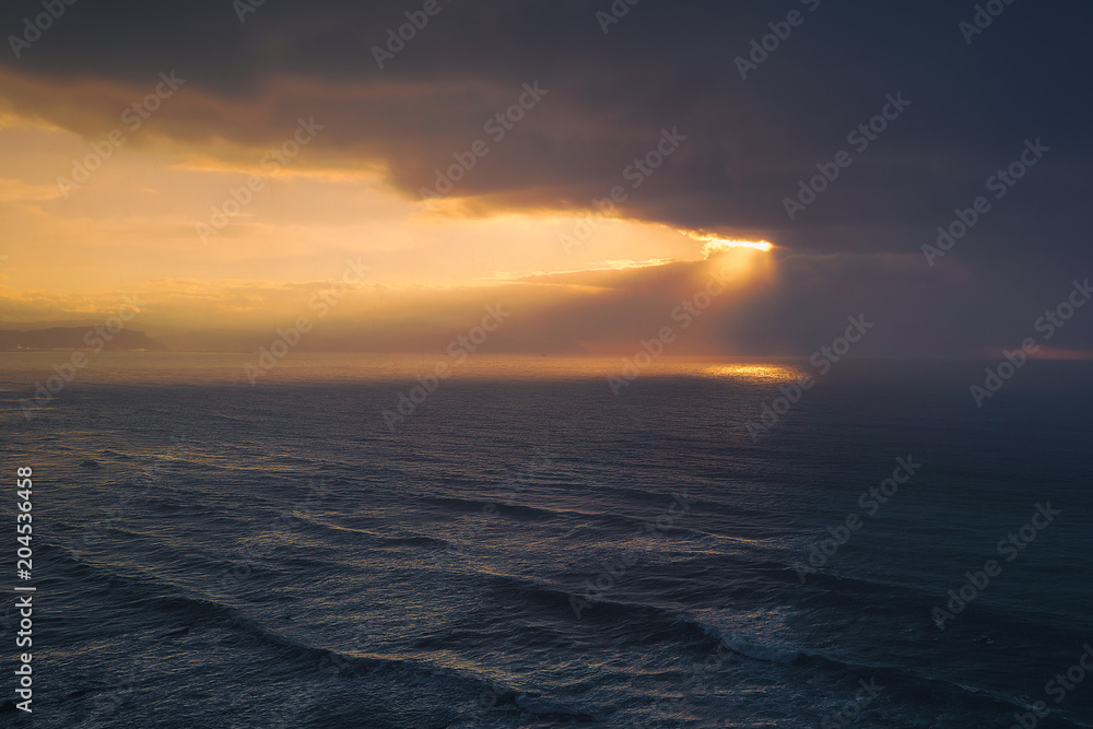 seascape with golden sun rays and stormy clouds