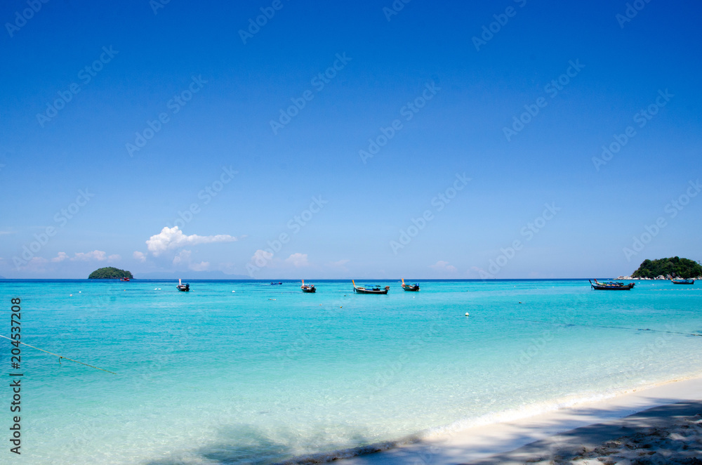 Turquoise sea And blue sky White Sand Beach with taxi long tail boat, travel concept. Koh Lipe, Satun, Thailand