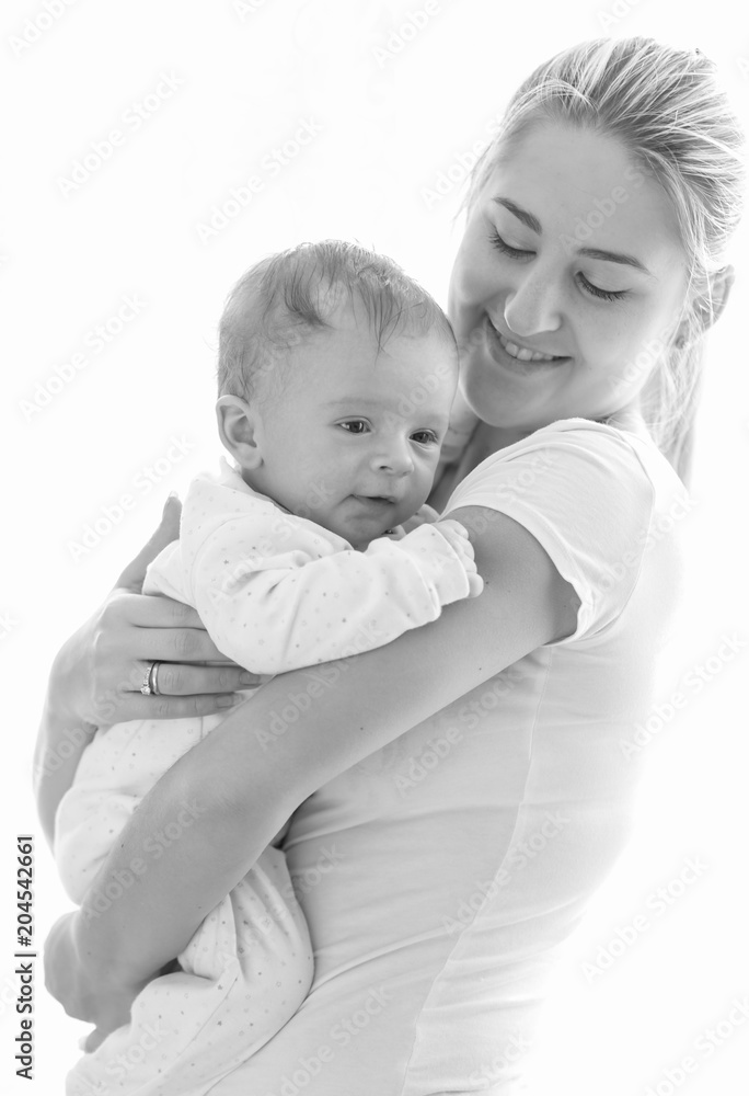 Black and white isolated portrait of young mother hugging her baby Black and white isolated portrait of young mother hugging her baby