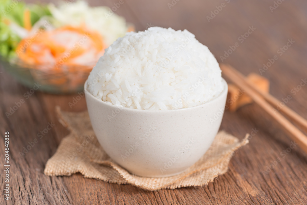 White rice in bowl with chopsticks on table. White rice in bowl with chopsticks on table.