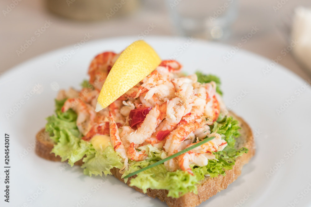 Sandwich with shrimp and lemon on plate. Sandwich with shrimp and lemon on plate.