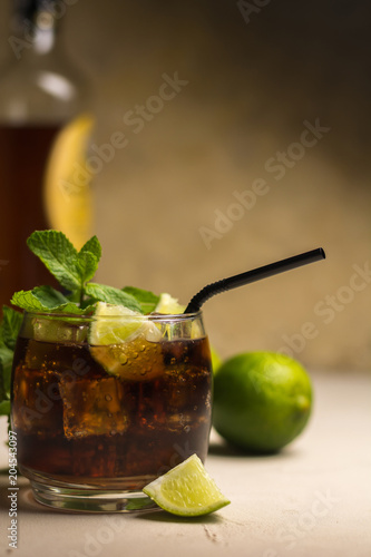 Cuba Libre drink with mint leaves and pieces of lime. Alcoholic drink with rum and cola