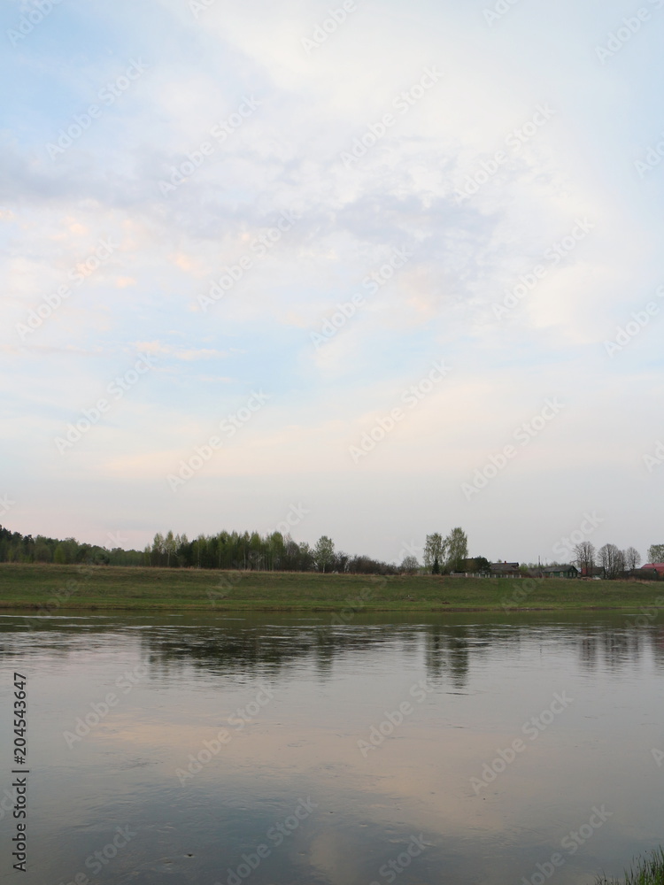 the banks of the spring river in the evening at sunset