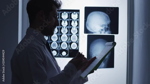 Doctor writing on a clipboard photo