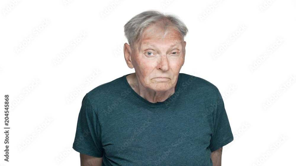 Portrait of displeased old aged man 80s having gray hair in basic t-shirt staring at you with suspicious gaze slow motion, isolated over white background Portrait of displeased old aged man 80s having gray hair in basic t-shirt staring at you with suspicious gaze slow motion, isolated over white background