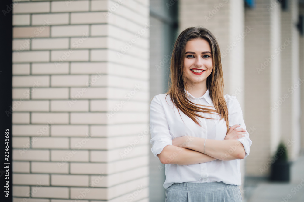Portrait of young smile woman in the street with arms crossed Portrait of young smile woman in the street with arms crossed