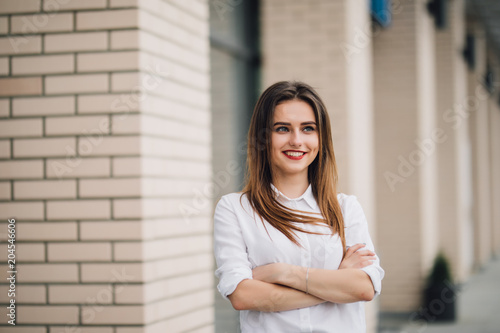 Confident woman looking at the camera while standing on the street with crossed hands Free Download Confident woman looking at the camera while standing on the street with crossed hands - GFXLoad
