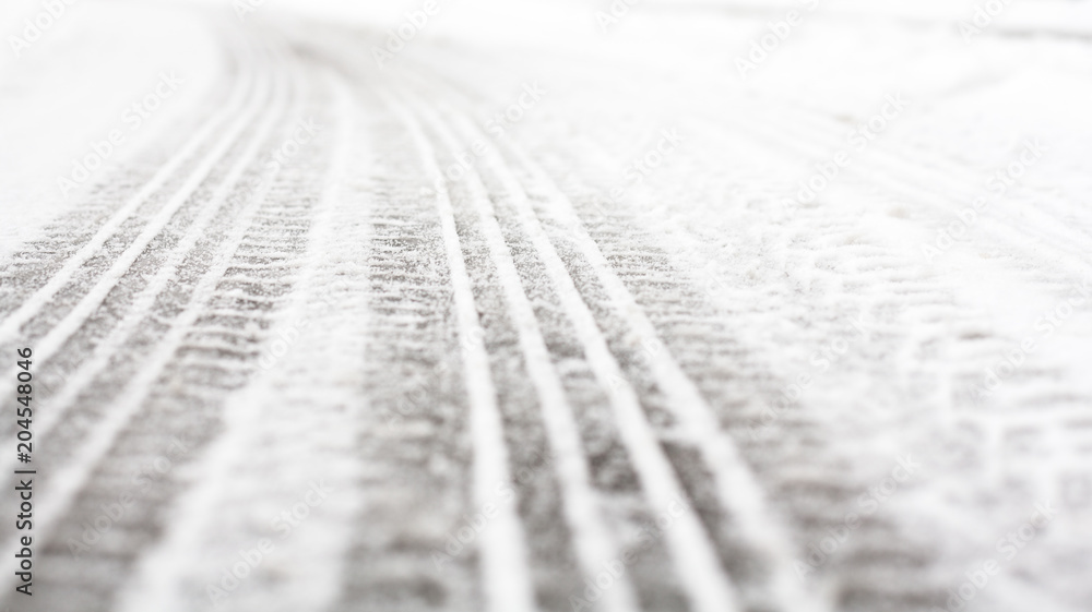 Wheel tracks on the road covered with snow